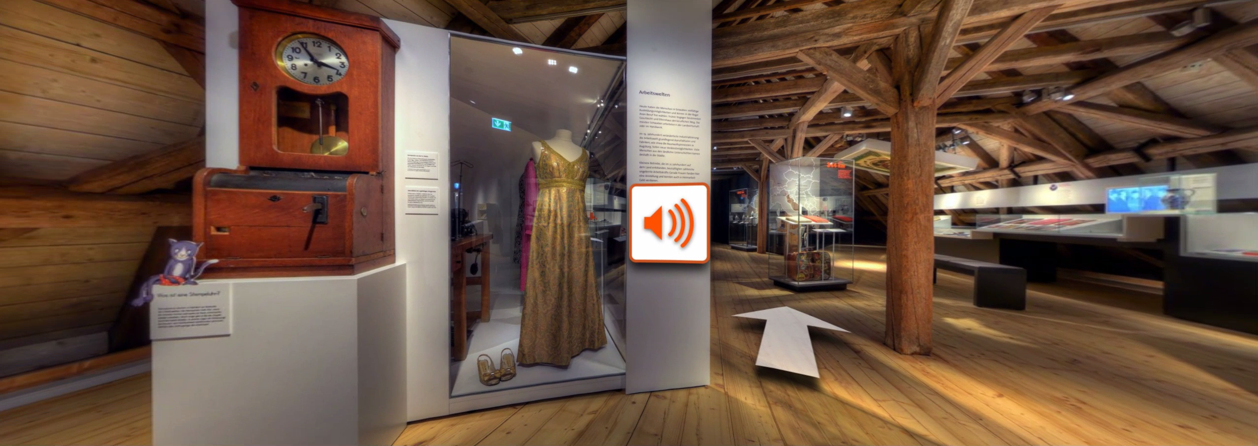 Bildschirmfoto aus dem virtuellen Rundgang: Panoramafoto in einem Ausstellungsraum mit Pfeil-Symbol für die Navigation und einem Lautsprecher-Symbol für einblendbare Erklärungen